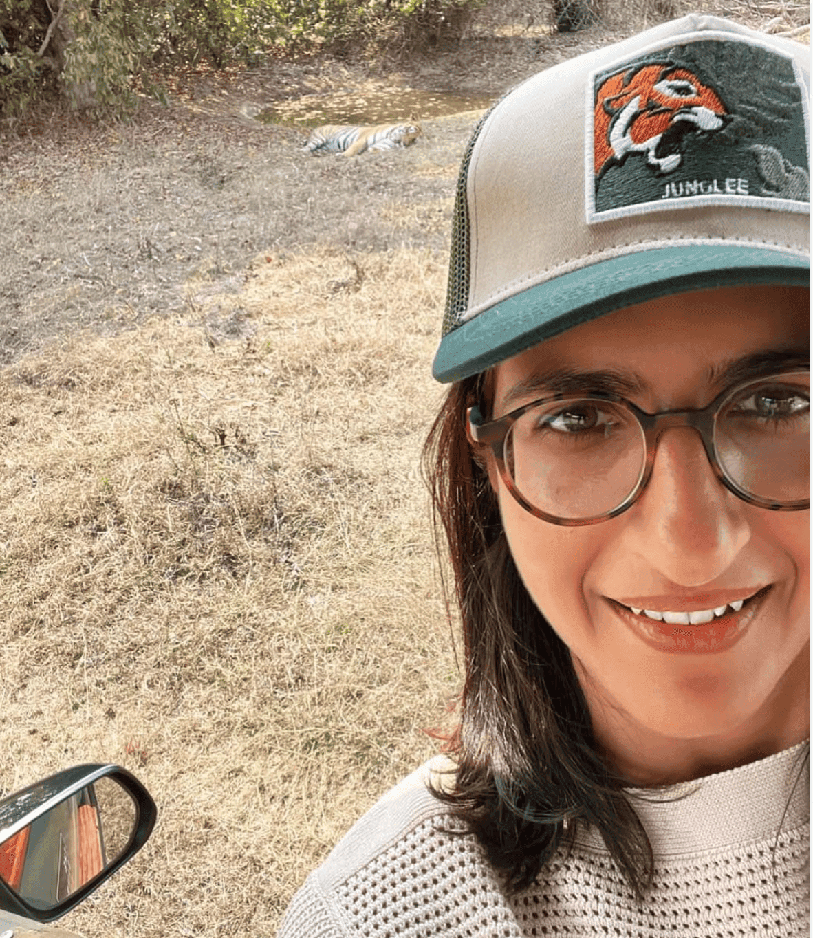 A real tiger, resting in the grass just behind — the patch on the cap got a little too on the nose that day.